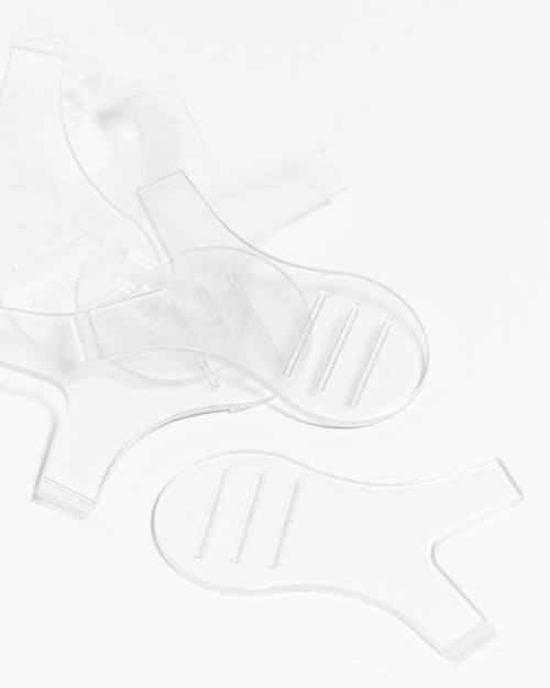 close up angle of multiple professional lash extensions lift Y Tools for lash lifts piled together on a white background.
